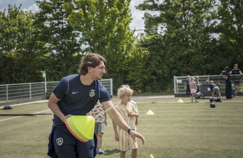 Trainer die pionnen uitzet voor zijn training op het voetbalveld