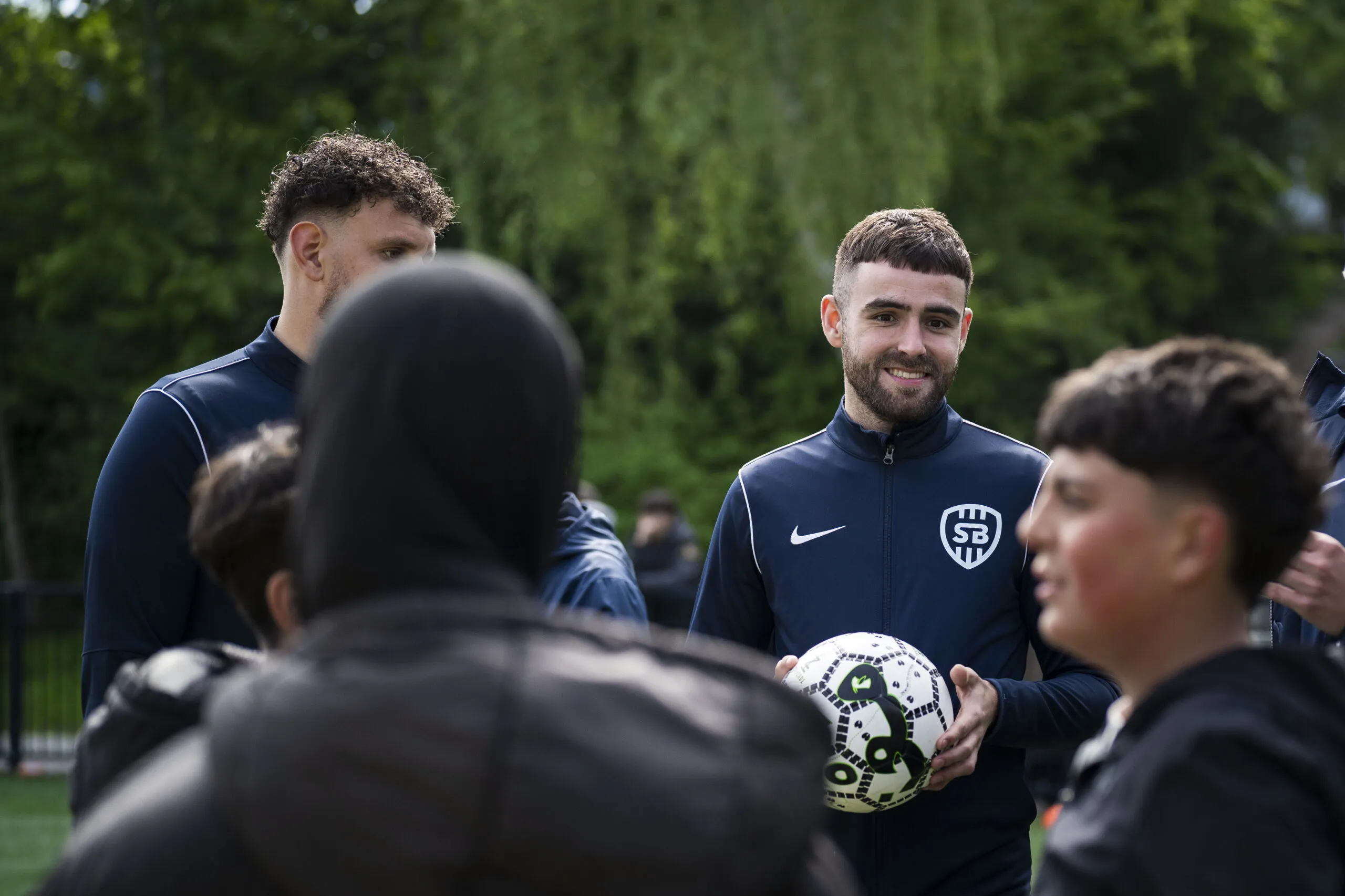 Voetbaltrainers met jeugd op het veld