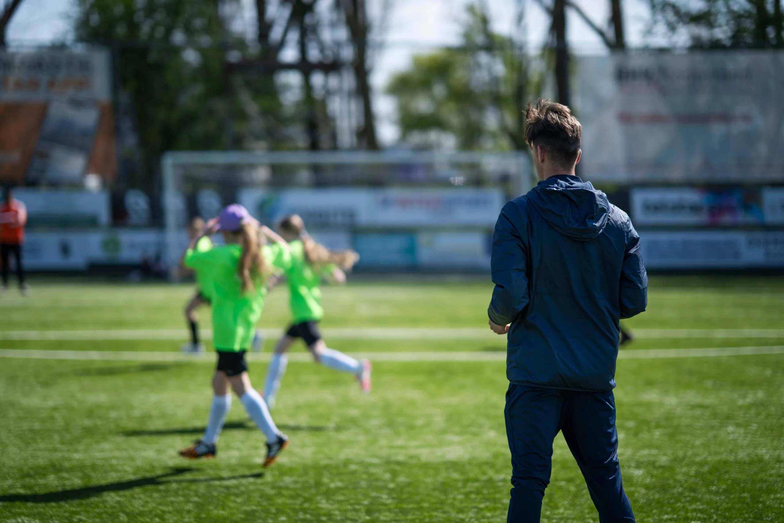 Een coach die training geeft aan basisschool kinderen op een sportveld
