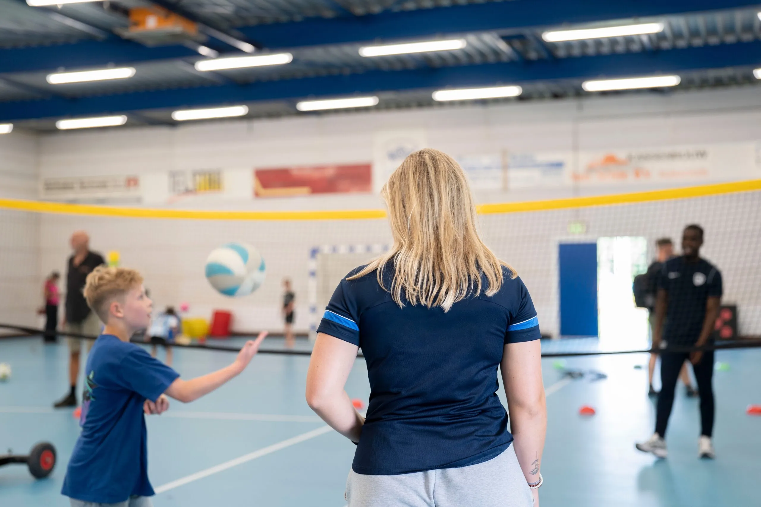 Kinderen spelen volleybal in de sporthal
