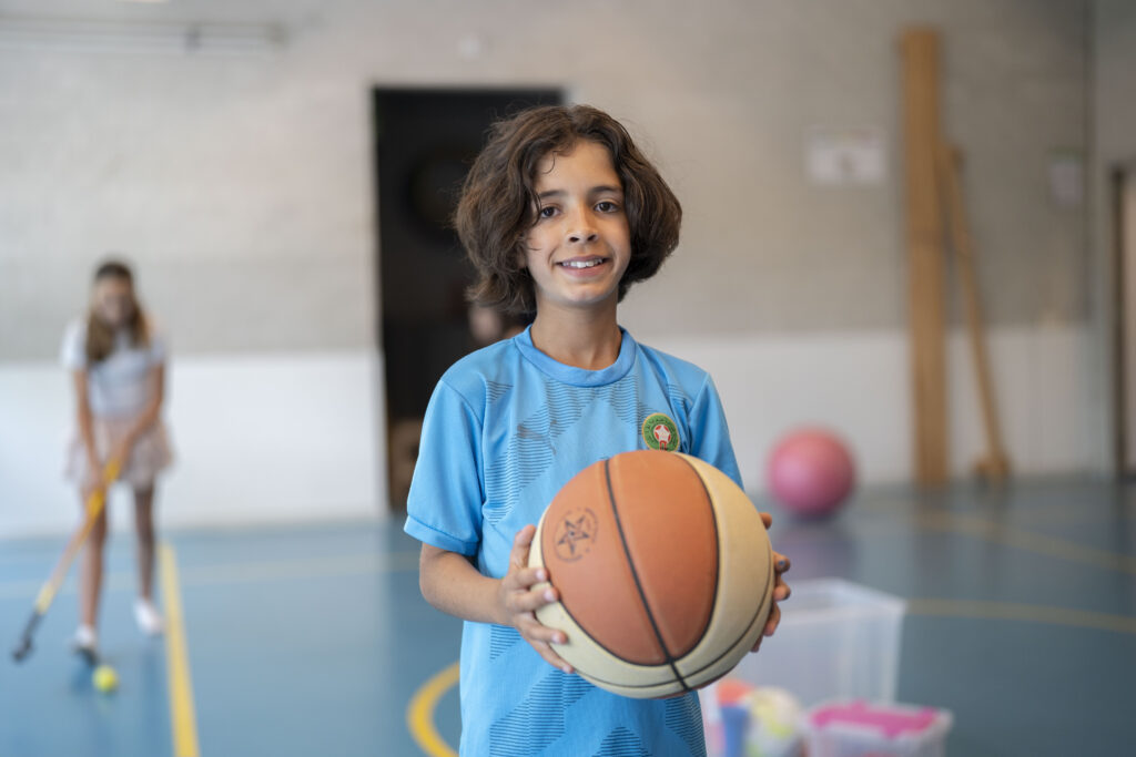 Jongen met basketbal in de gymzaal