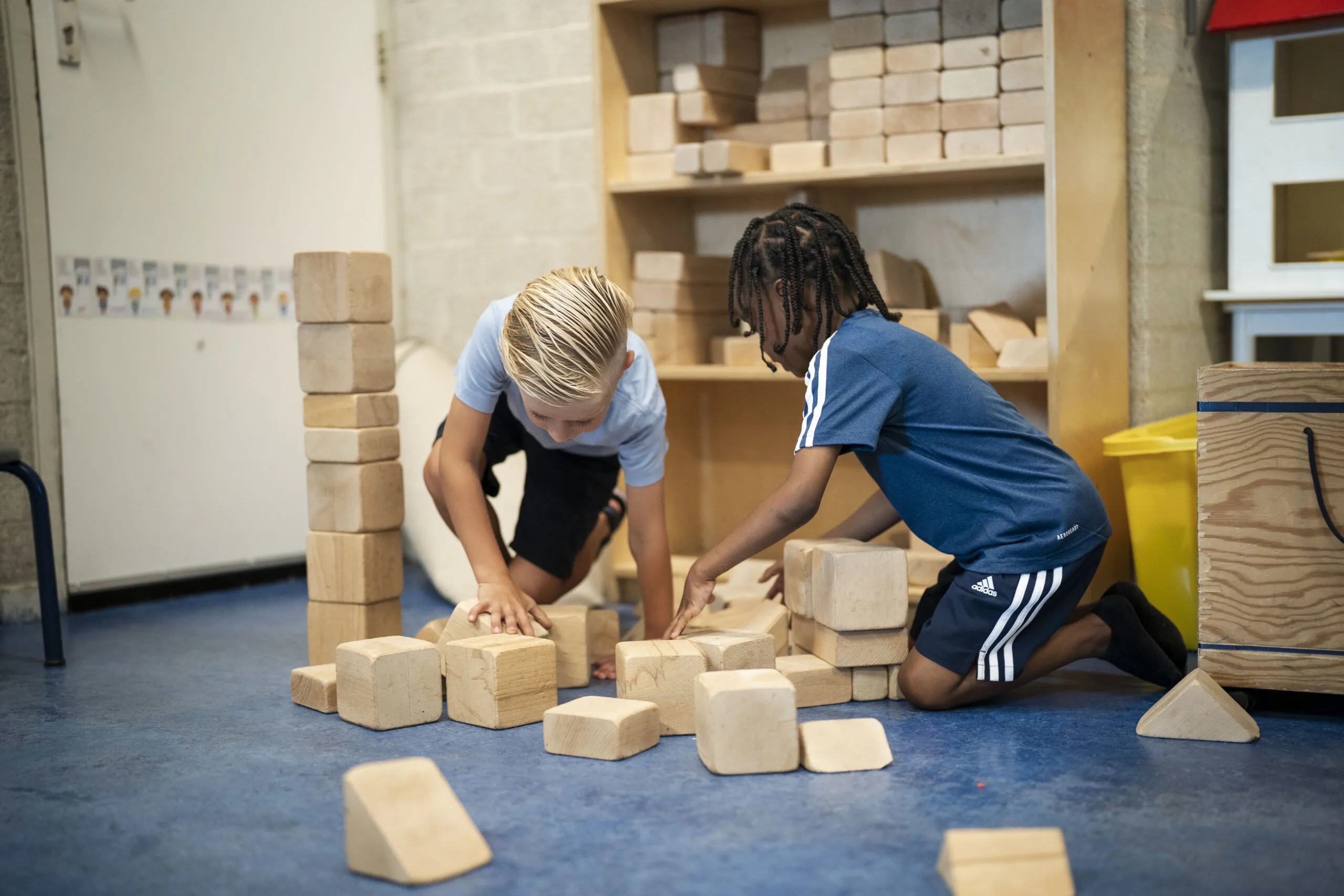 Twee basisschool jongens stapelen houten blokken