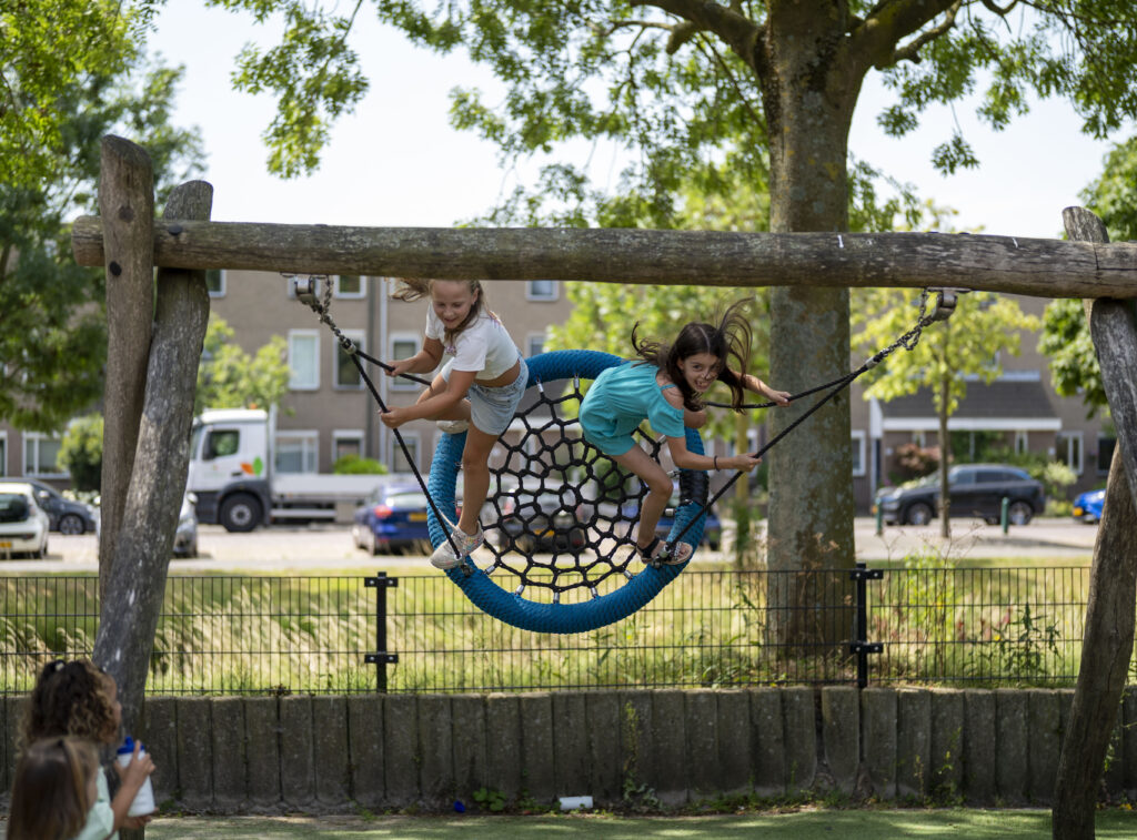 Basisschool kinderen schommelen op de speelplaats