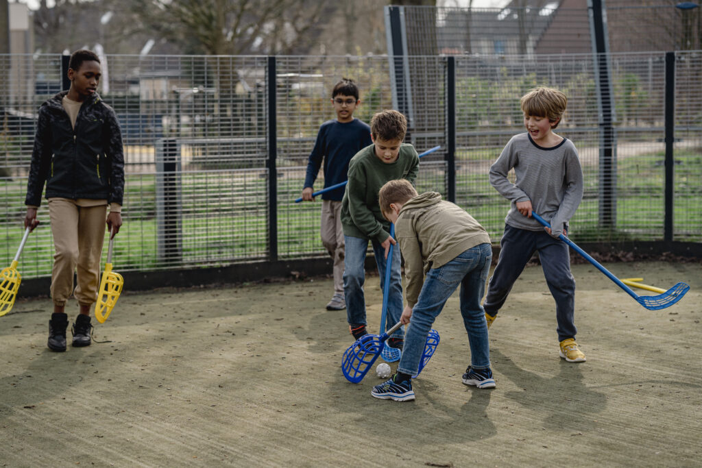 Jongens van de middelbare school die hockey spelen